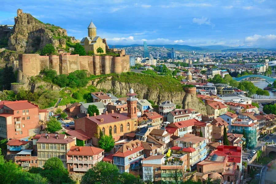 Blick über die bunten Häuser der Tifliser Altstadt zur Festung Narikala.
